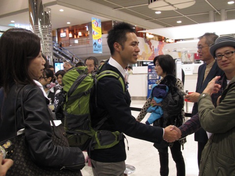 見送りに訪れた家族と握手を交わす水田氏