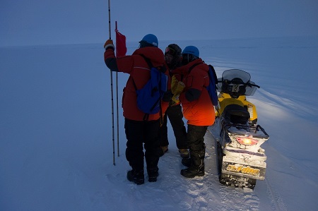 ルート工作中に海氷上で積雪を計測している様子