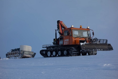 ドラム缶を積載した橇を引く雪上車