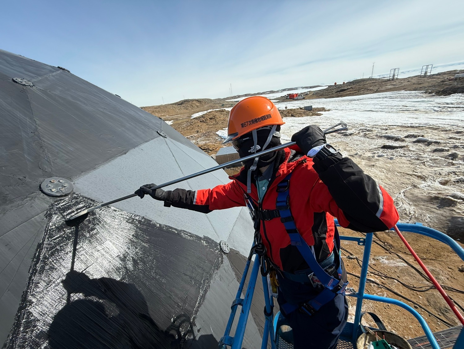 高所作業車に乗りレドームのパネルを補修している様子