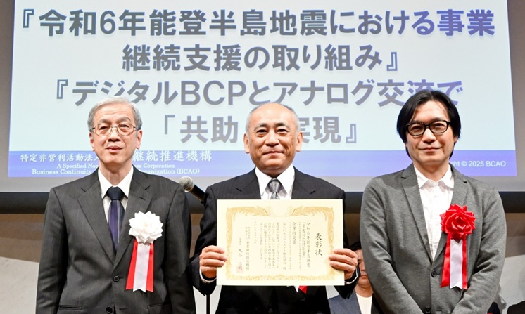 表彰式で3名が表彰状を手に並んでいる様子